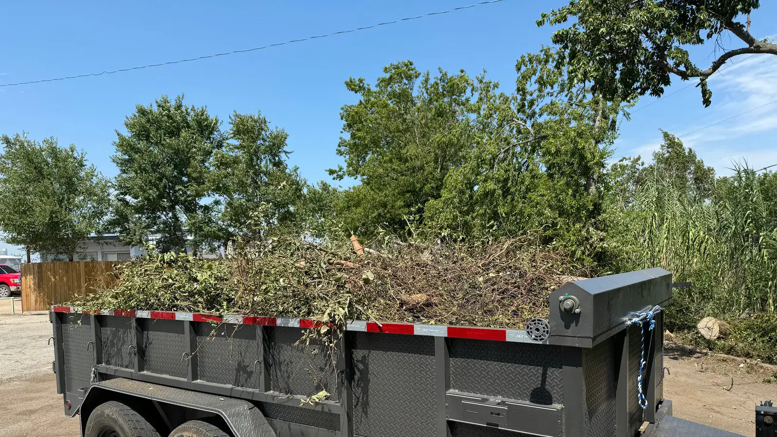 Dump trailer loaded to the rails with cut brush and limbs hauled off a cleared property